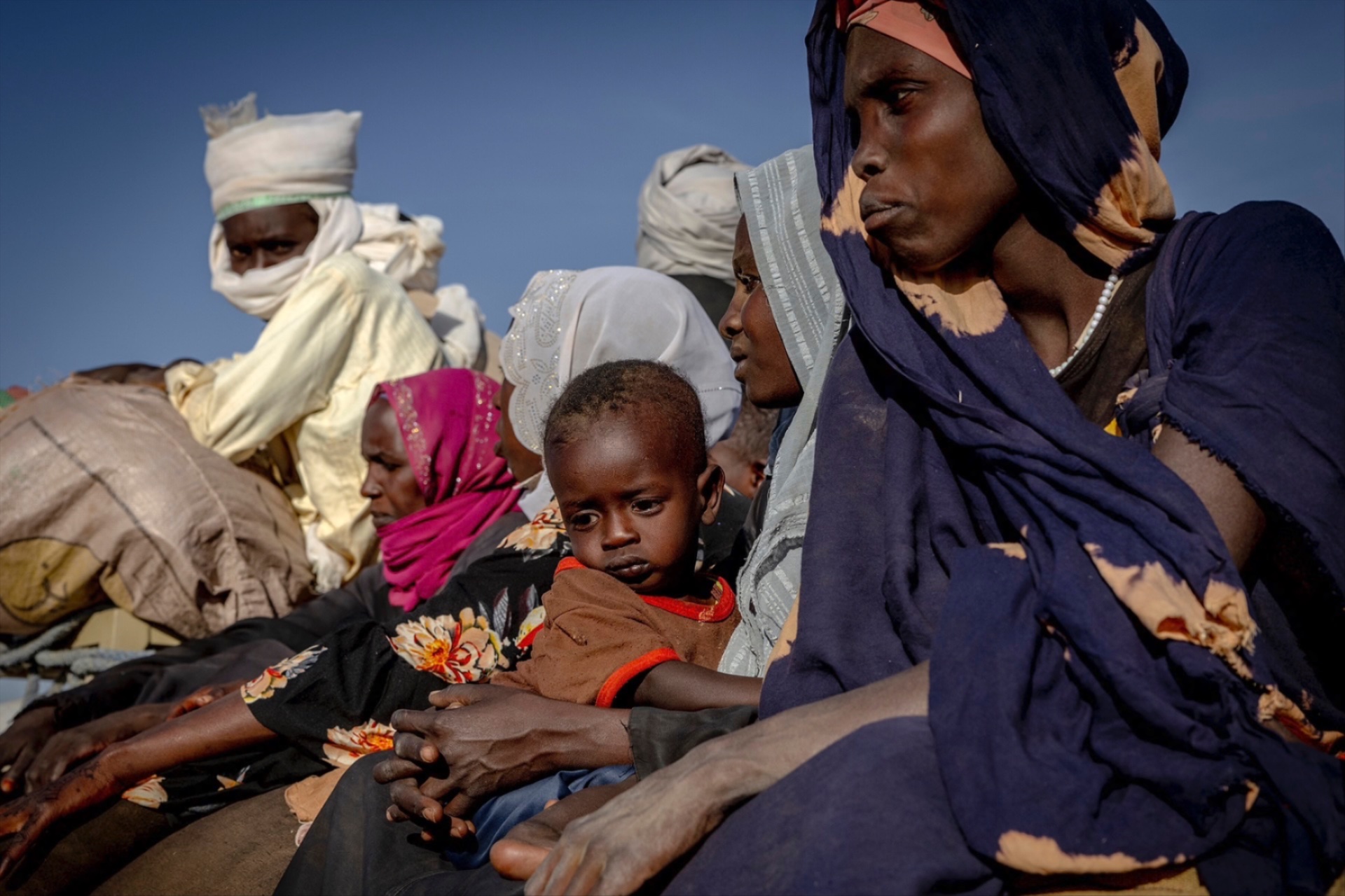 Exhausted and covered in dust, a truck full of Sudanese refugees arrive on the outskirts of Oure Cassoni refugee camp in eastern Chad on November 30, 2025.