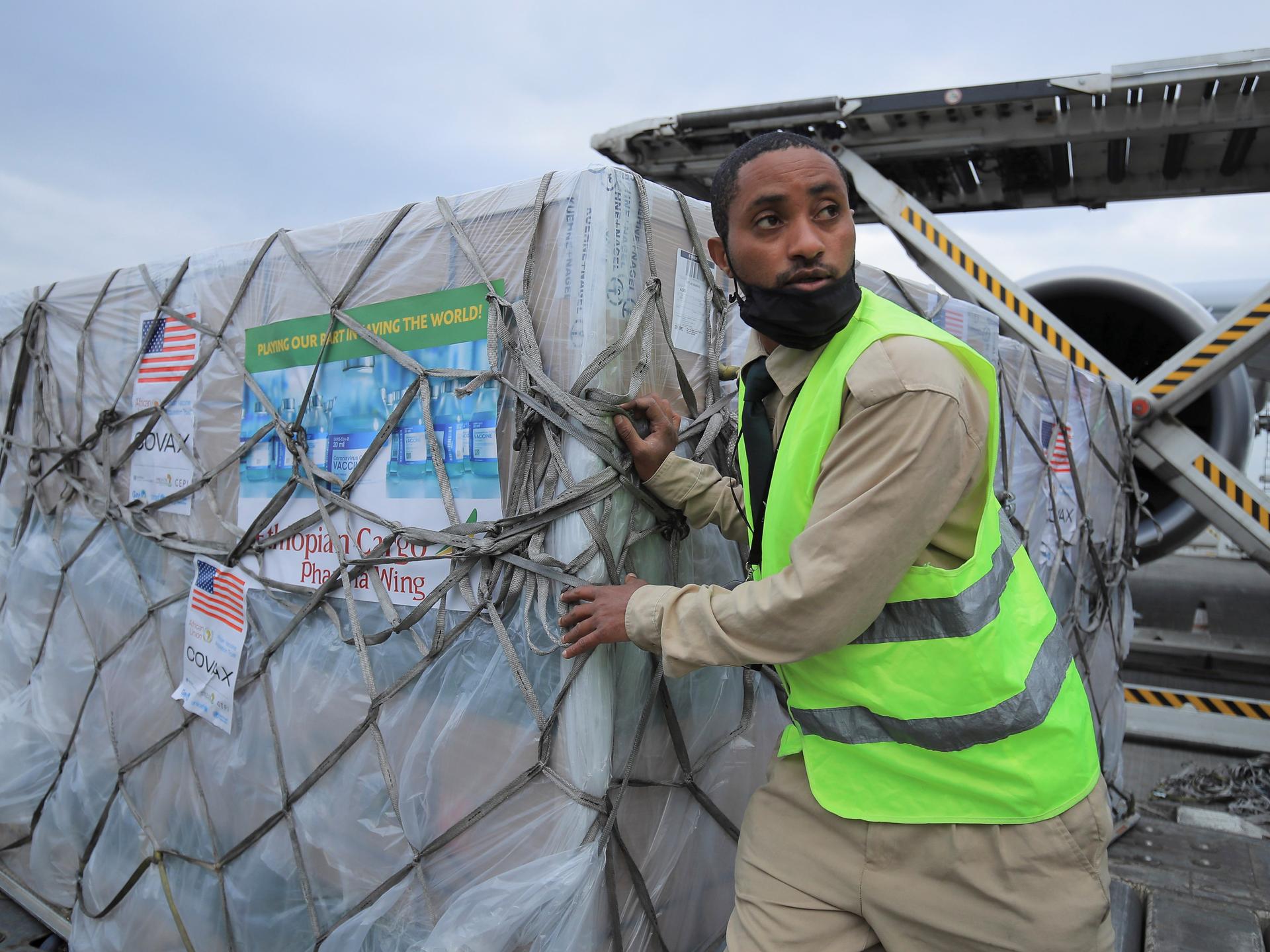 An Ethiopian Cargo terminal worker offloads a shipment of Johnson & Johnson's COVID-19 vaccines that arrived under the COVAX scheme, at the Bole International Airport, in Addis Ababa, Ethiopia, on July 19, 2021.