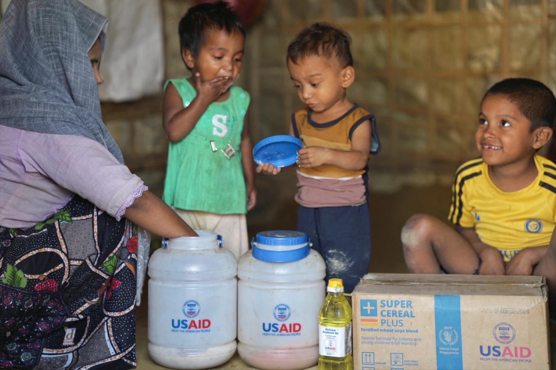 Rohingya children eat from jars with the USAID logo on them, at a refugee camp in Cox's Bazar, Bangladesh, February 11, 2025.
