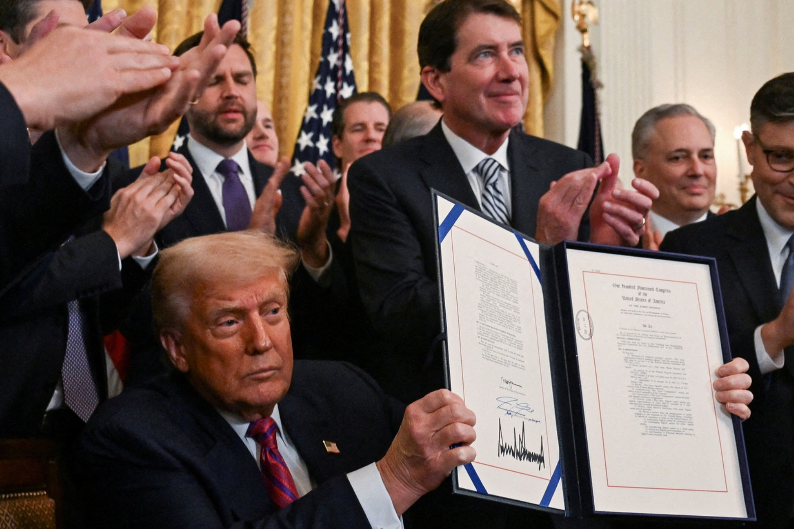 U.S. President Donald Trump holds the signed 'Genius Act', which will develop regulatory framework for stablecoin cryptocurrencies and expand oversight of the industry, at the White House in Washington, D.C., U.S., July 18, 2025. REUTERS/Annabelle Gordon/File Photo