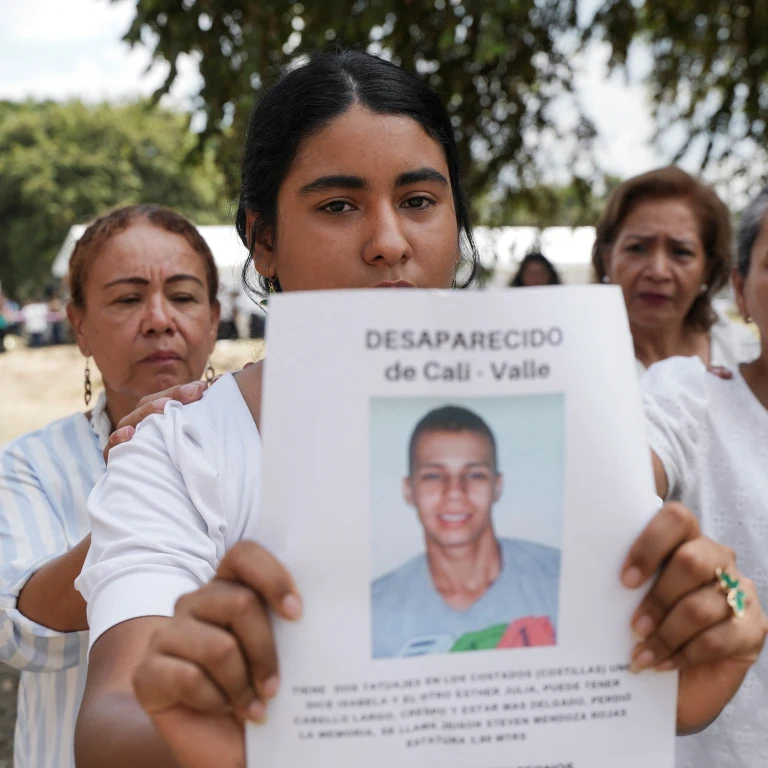 A woman holds a picture of a victim of forced disappearance