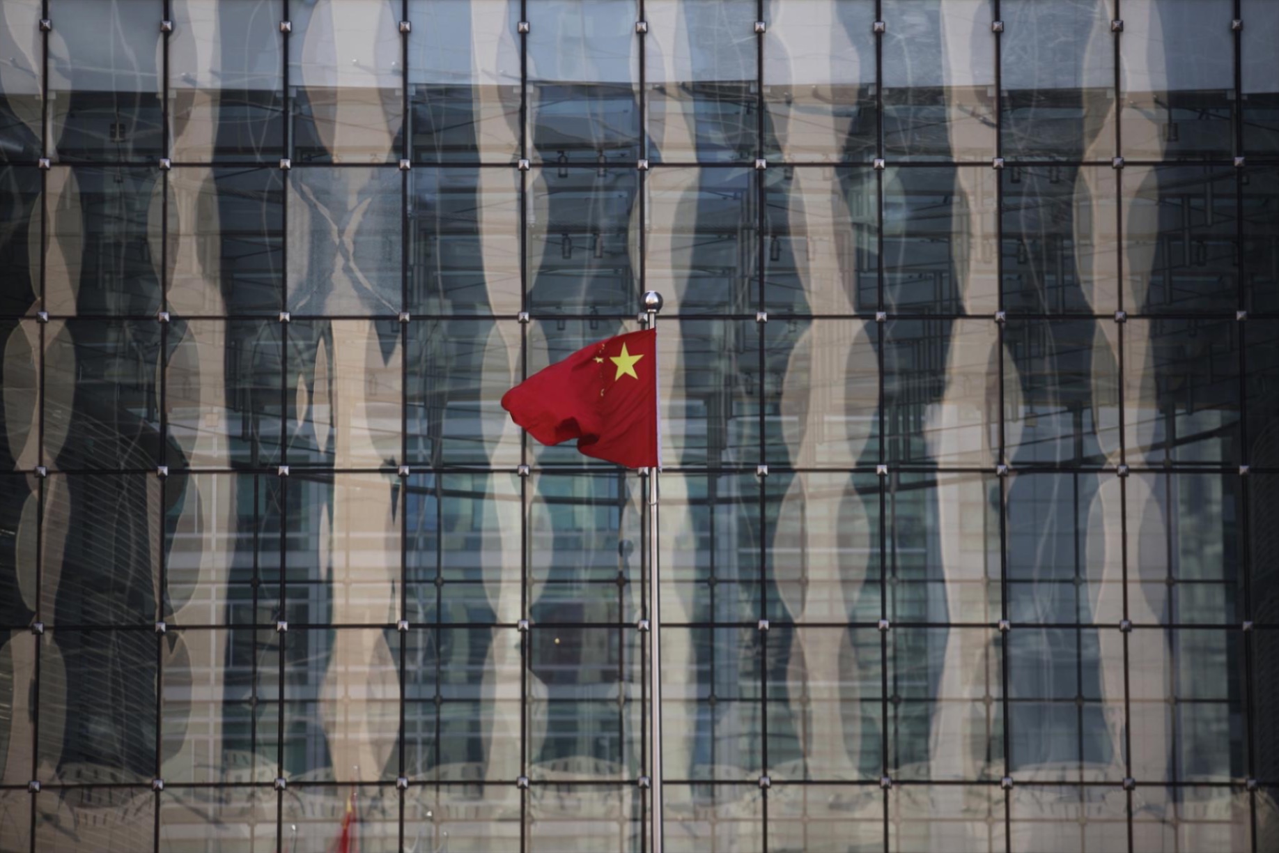 A Chinese national flag flutters at the headquarters of a commercial bank on a financial street near the headquarters of the People's Bank of China, China's central bank, in central Beijing.