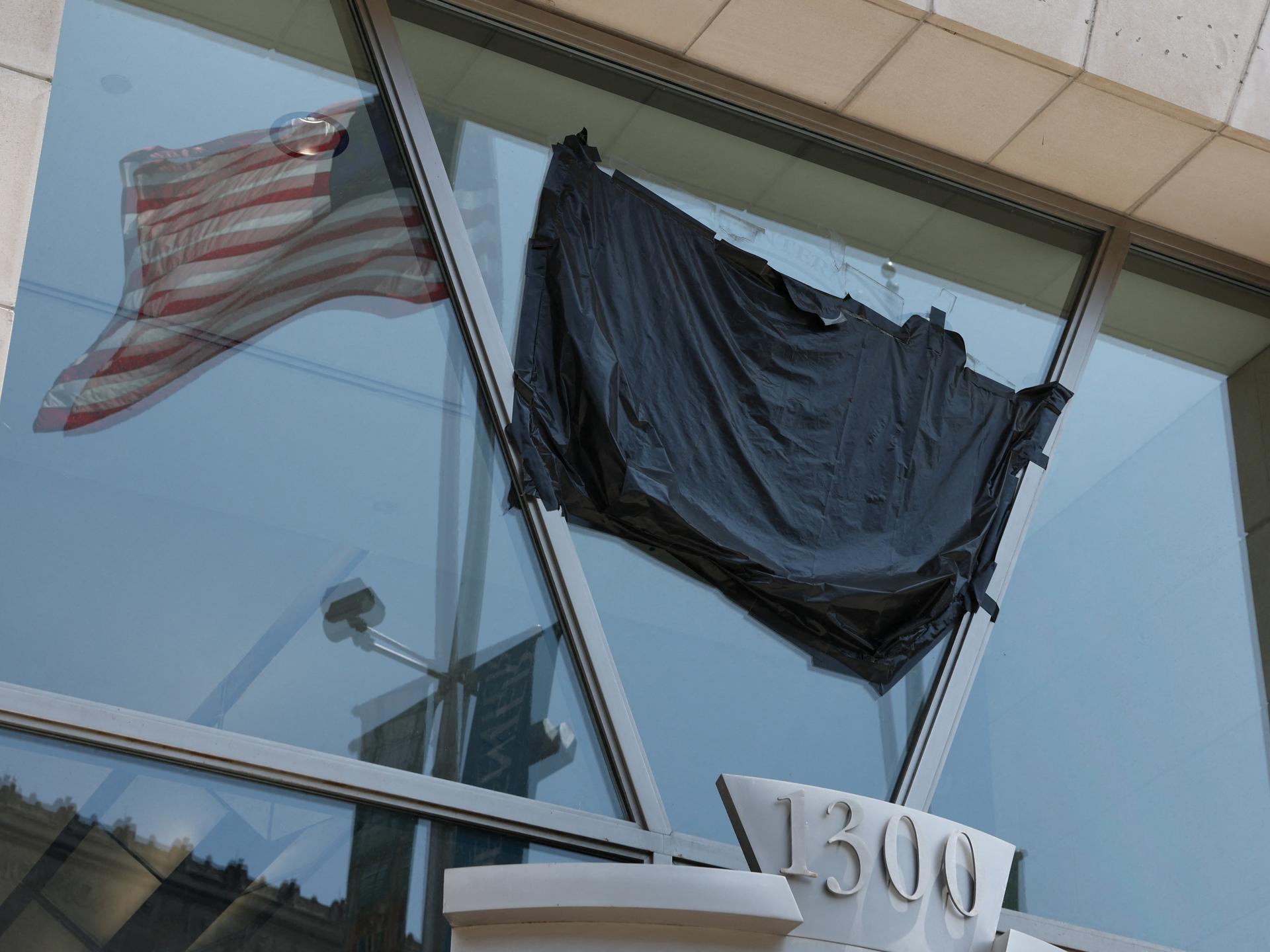 A U.S. flag is reflected in the windows of the shuttered former offices of the U.S. Agency for International Development (USAID) in Washington, DC, on July 22, 2025.
