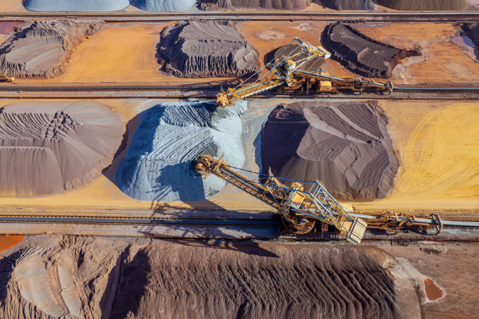 An overhead view shows large machinery at work in a metal mine