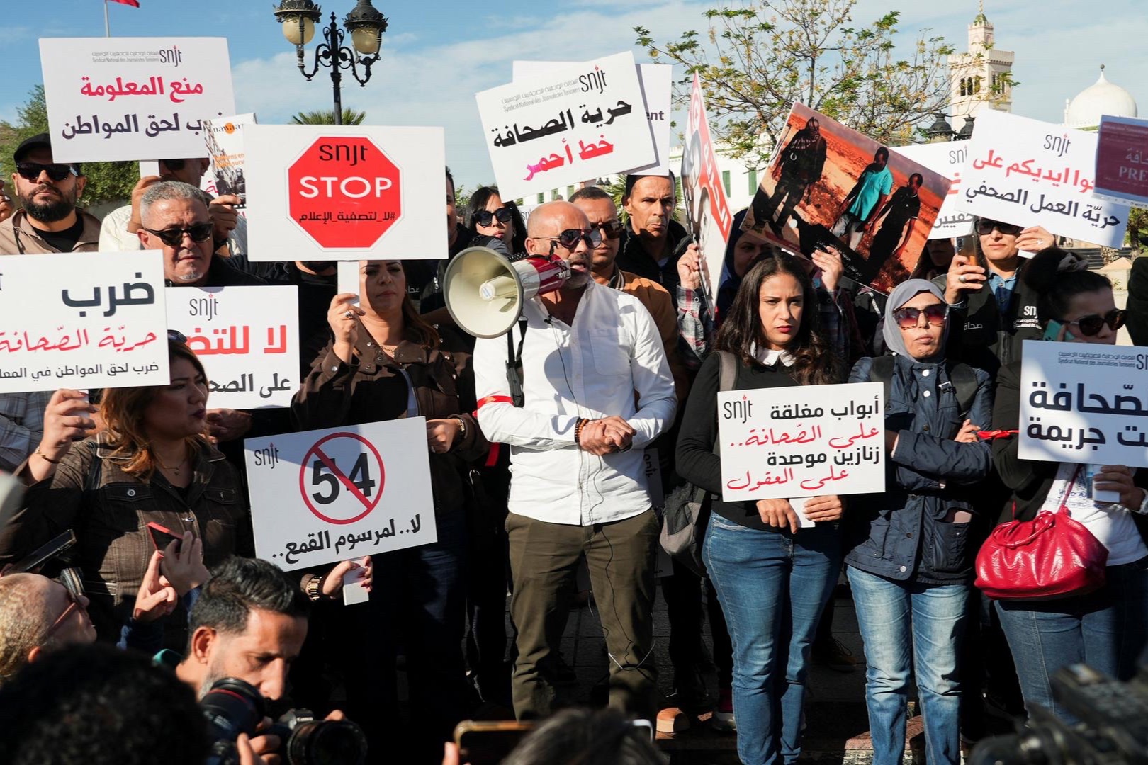 Tunisian journalists rally near the government's office, holding signs to protest press restrictions, in Tunis, Tunisia, November 20, 2025.