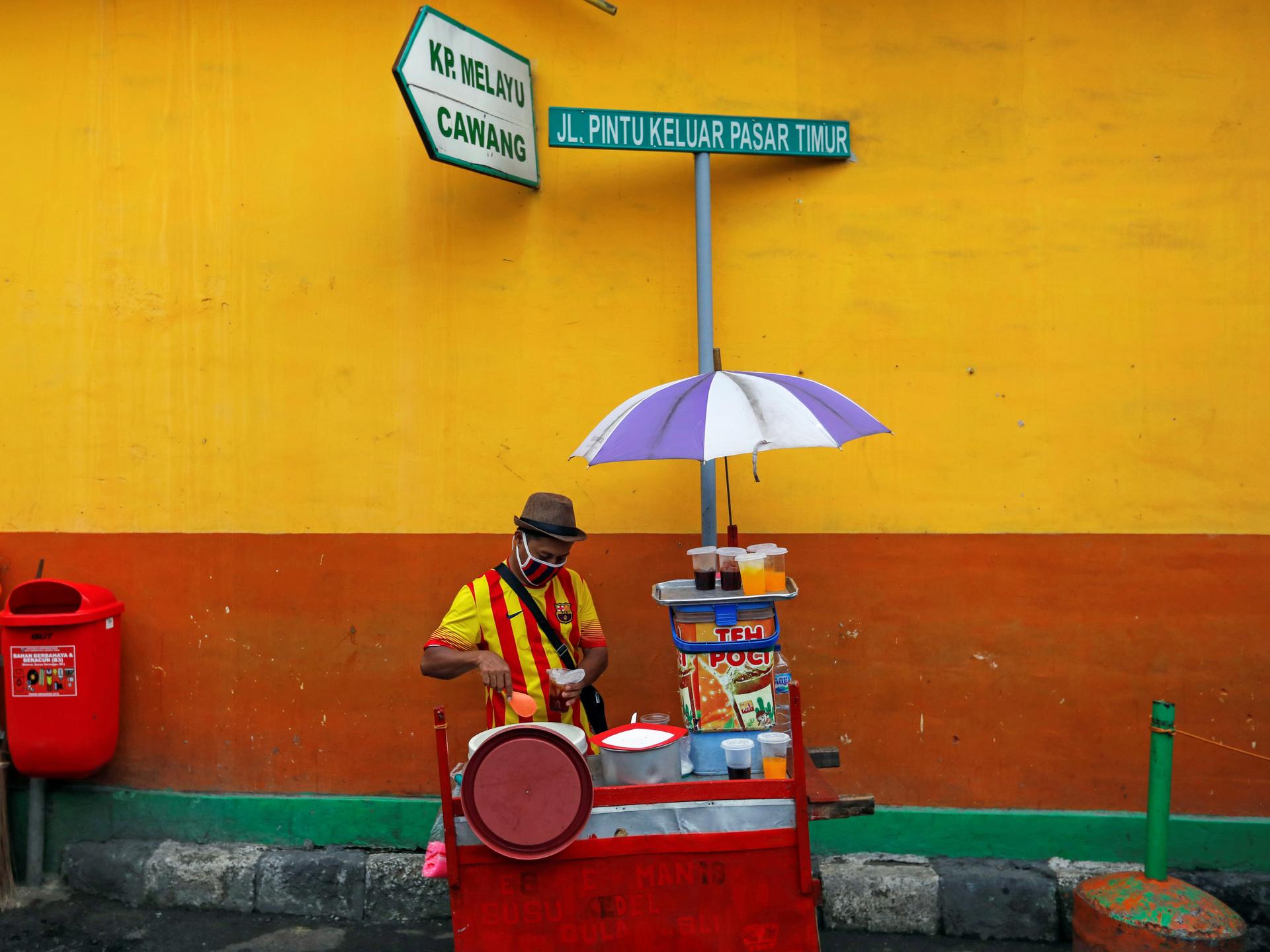 A street vendor prepares drinks for sale at Jatinegara, a traditional market, in Jakarta, Indonesia, on May 21, 2020.