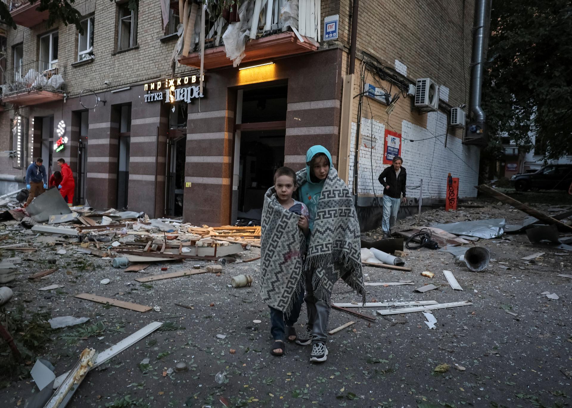 Residents at the site of an apartment building hit during Russian drone and missile strikes in Kyiv, Ukraine, on August 28, 2025. 