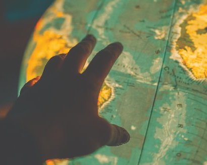Hand touching a lit up globe