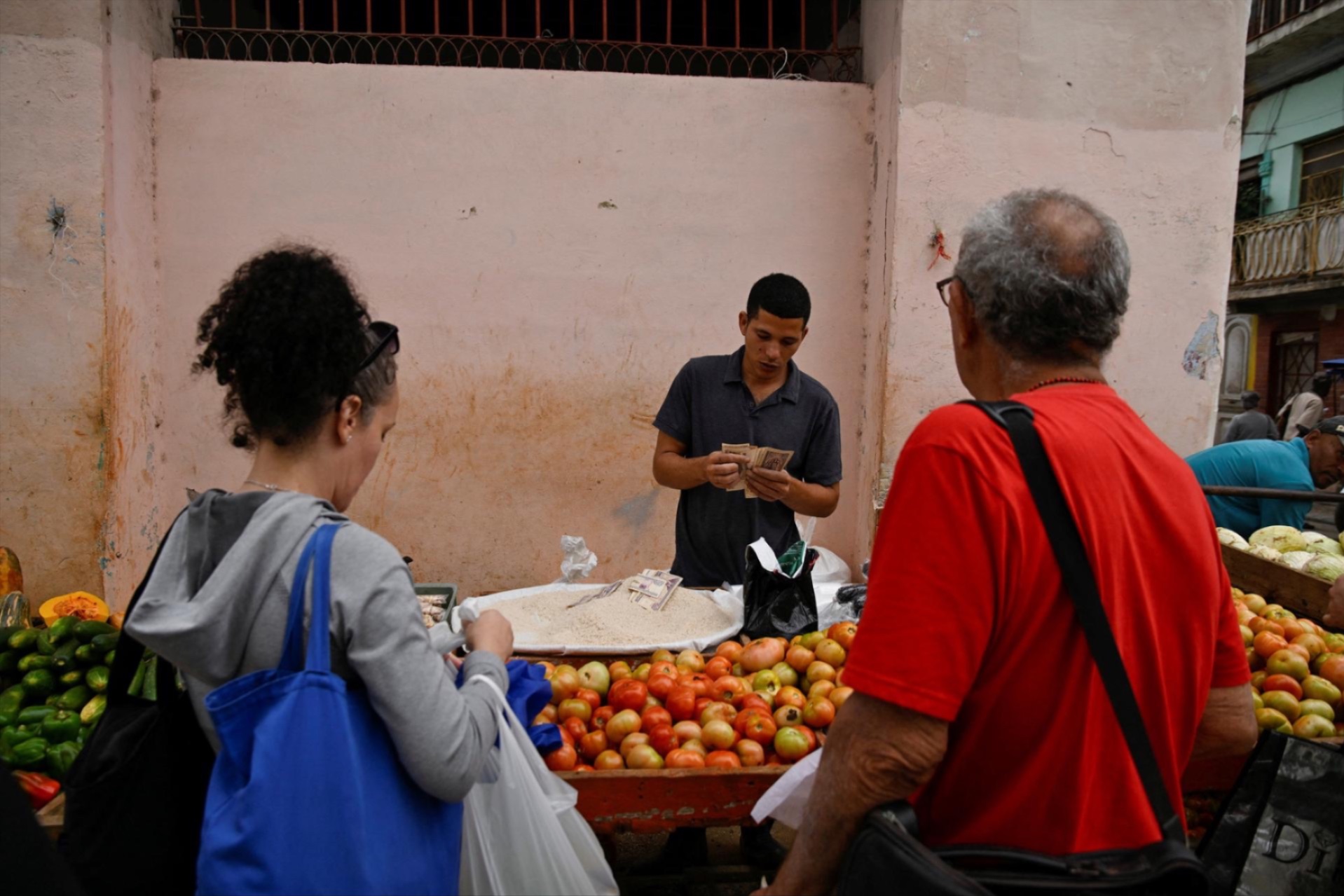 A vendor counts Cuban pesos at a street market as top officials of the National Assembly announce that the economy is predicted to grow 1% in 2026, in Havana, Cuba December 18, 2025.