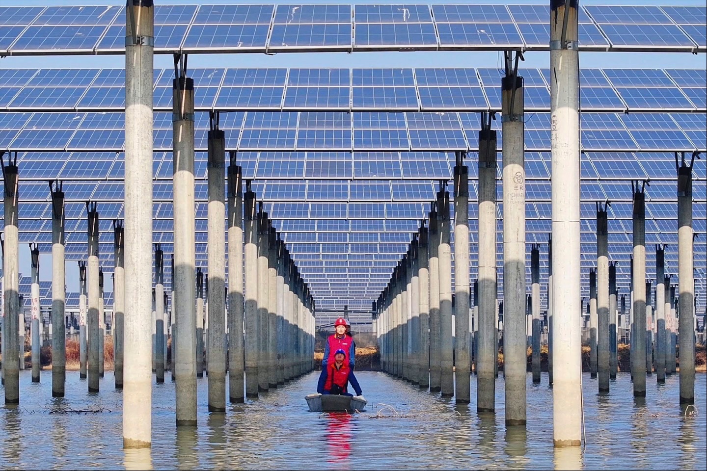 Workers check solar panels installed on a lake in Tianchang, east China’s Anhui province, on January 12, 2026. 