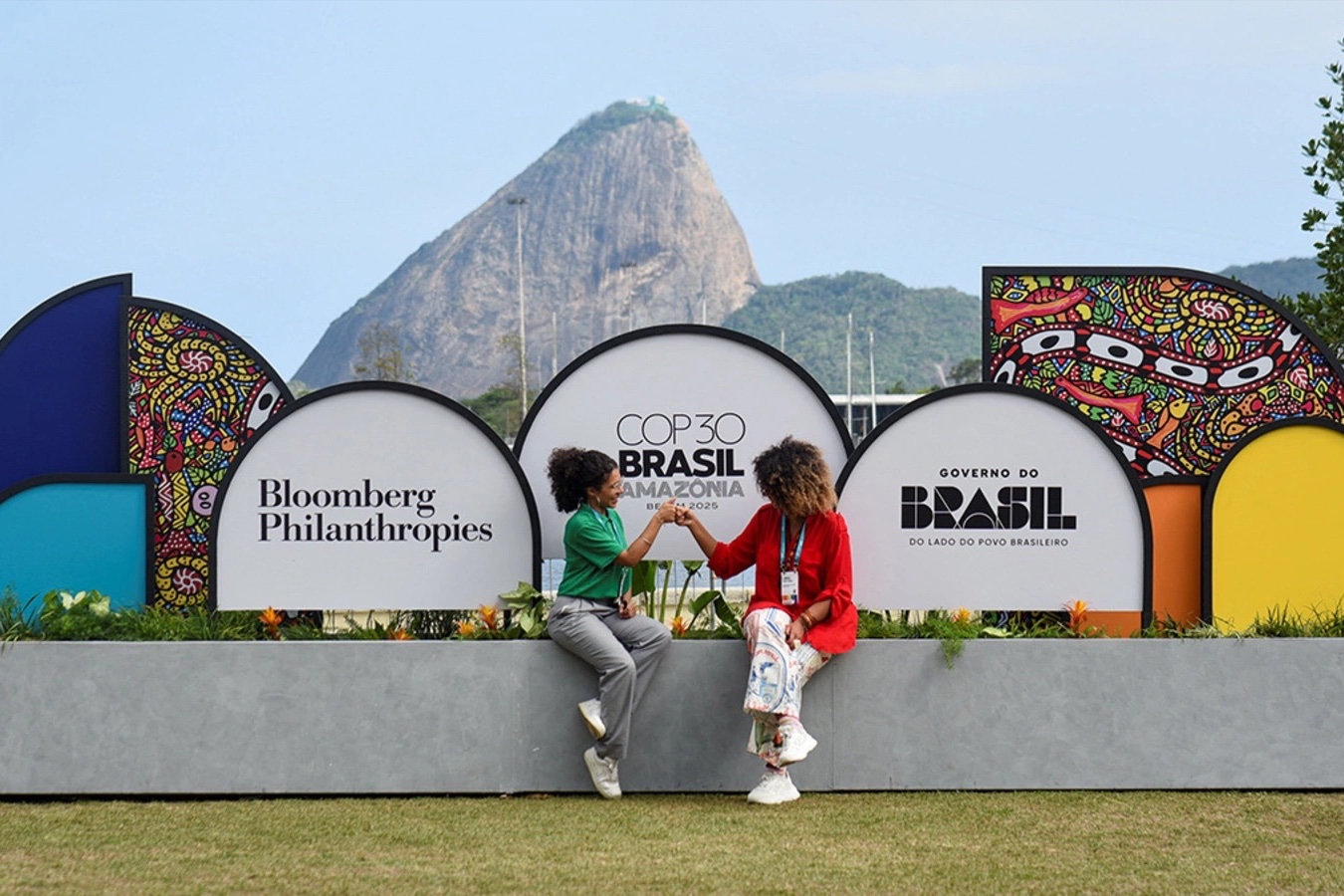 People sit near COP30 signage at the Museum of Modern Art in Rio de Janeiro, Brazil, November 4, 2025.