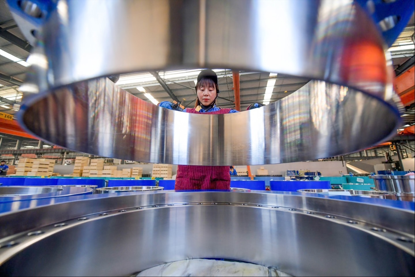 A worker manufactures locking disc for wind turbine units at a factory in Luoyang, China, on December 11, 2025.