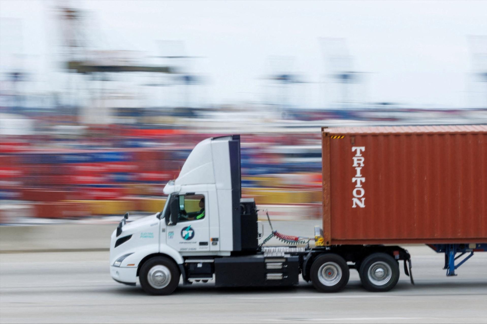 A semi-truck drives past Chinese shipping containers at the Port of Los Angeles in Wilmington, California, U.S., November 5, 2025. REUTERS/Mike Blake/File Photo
