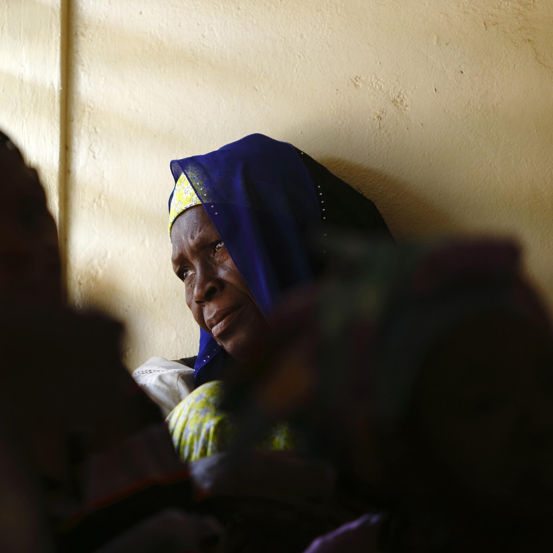A woman gazes out of a window while attending a talk on sexual health and HIV prevention, in the Tanghin neighborhood of Ouagadougou, Burkina Faso, on April 13, 2013. 