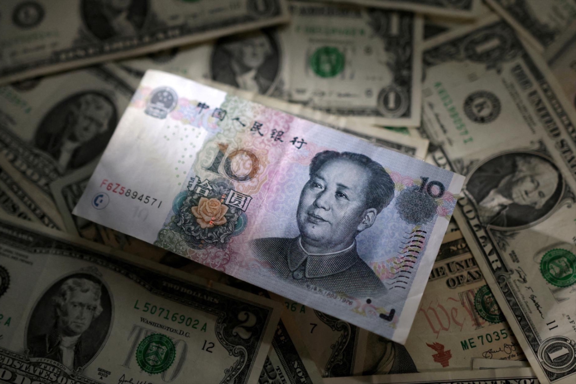 Chinese Yuan and U.S. dollar banknotes are seen in this illustration taken March 10, 2023.