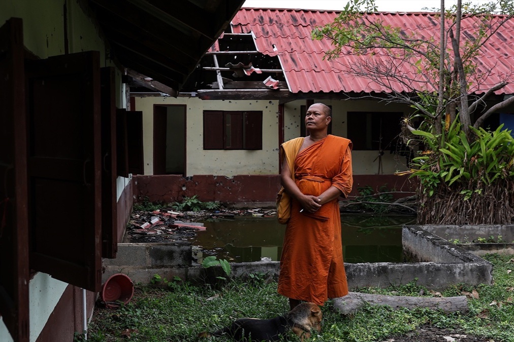 A monk stands near a damaged dorm at Thai Niyom temple, which was hit by Cambodian artillery during the Thailand-Cambodia border conflict in Surin Province, Thailand on November 3. 