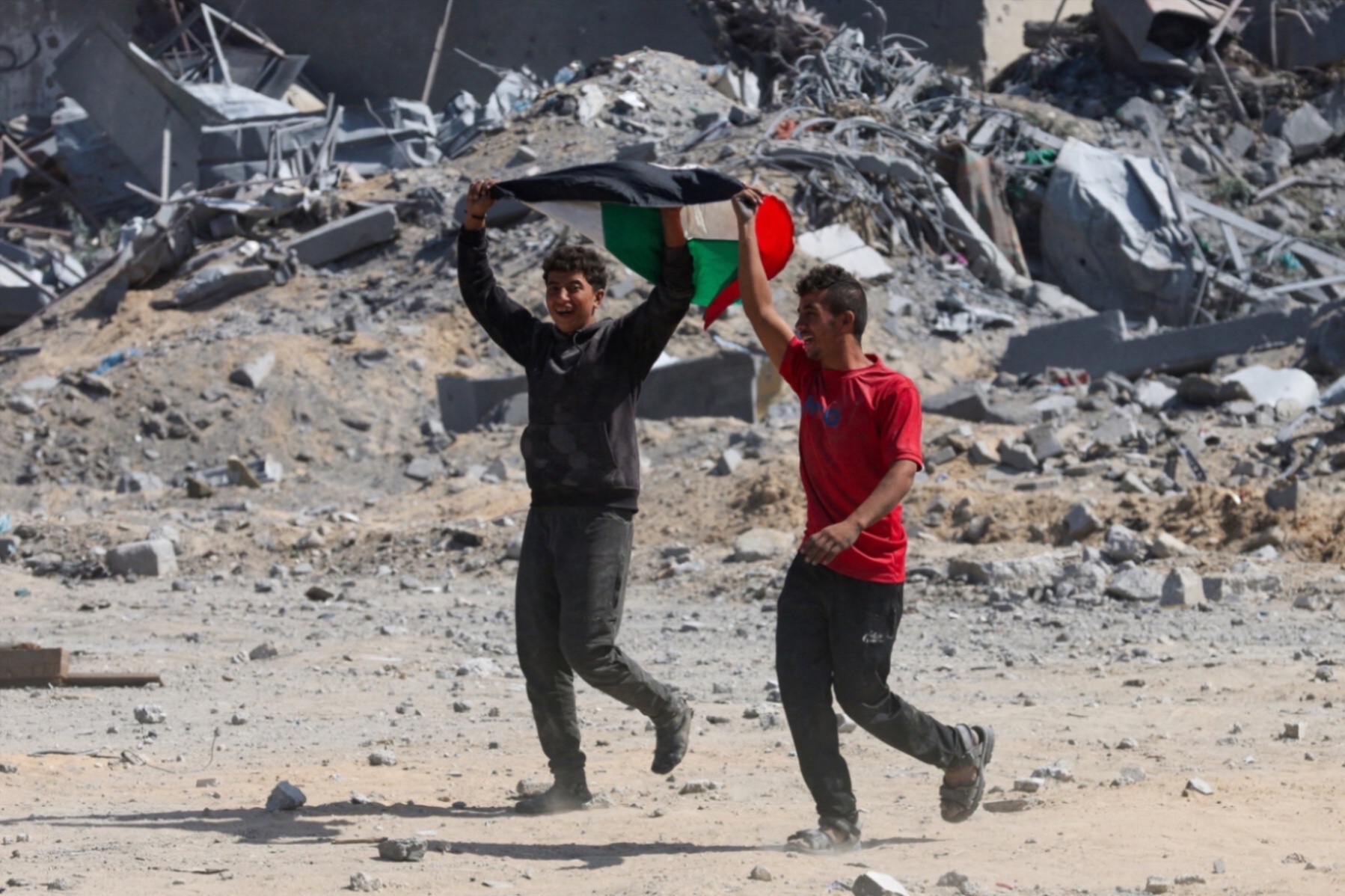 Two Palestinian youth react to the news of the ceasefire between Israel and Hamas from Khan Younis.