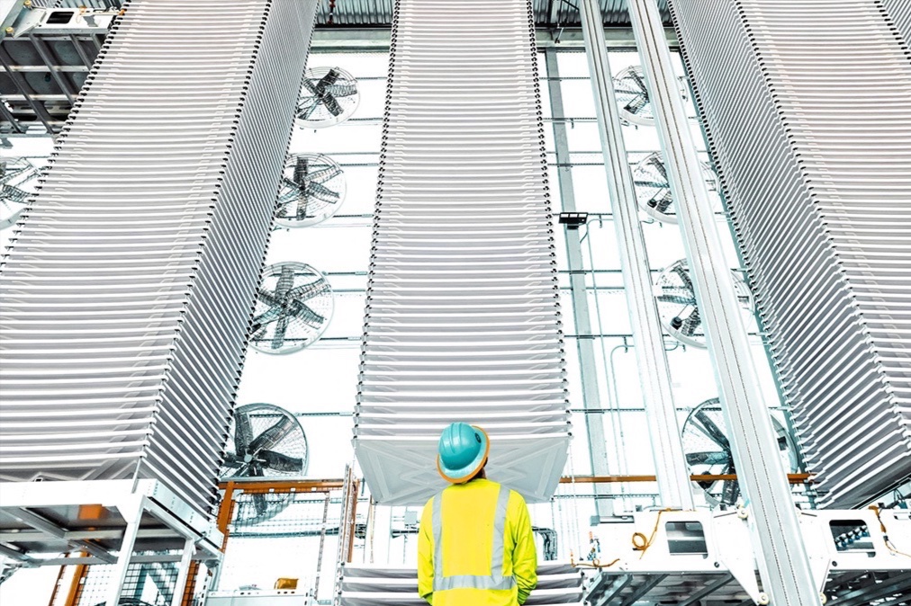 A person looks at stacks of trays holding treated limestone, used to absorb CO2 form the air, at a plant in Tracy, California.