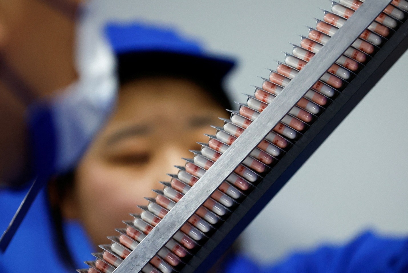 Employees examine cold-medicine products on a production line