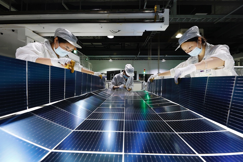 Employees work on the production line of solar panels at a workshop of Jiangsu DMEGC New Energy Co., Ltd. on July 22, 2025 in Suqian, Jiangsu Province of China.
