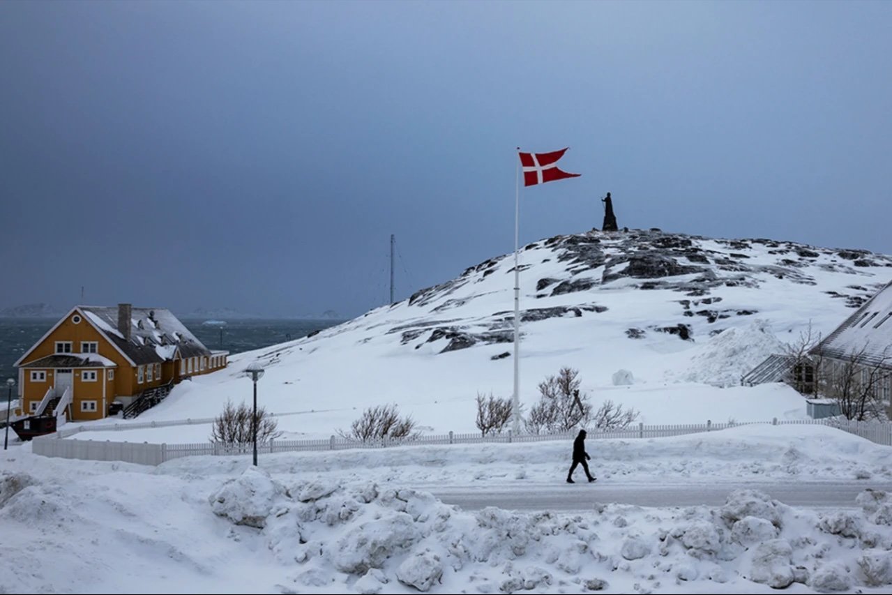A man passes a Danish flag ahead of Greenland’s general election in the island’s capital, Nuuk. 