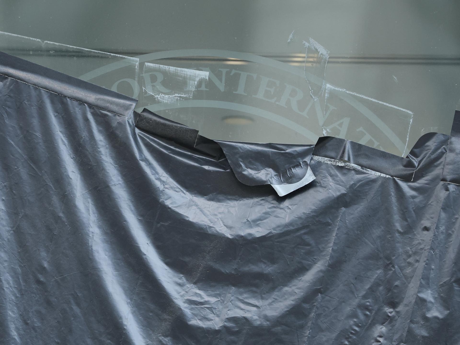 Plastic peels back to reveal the covered logo on the windows of the shuttered offices of the U.S. Agency for International Development, in Washington, DC, on  July 22, 2025. 