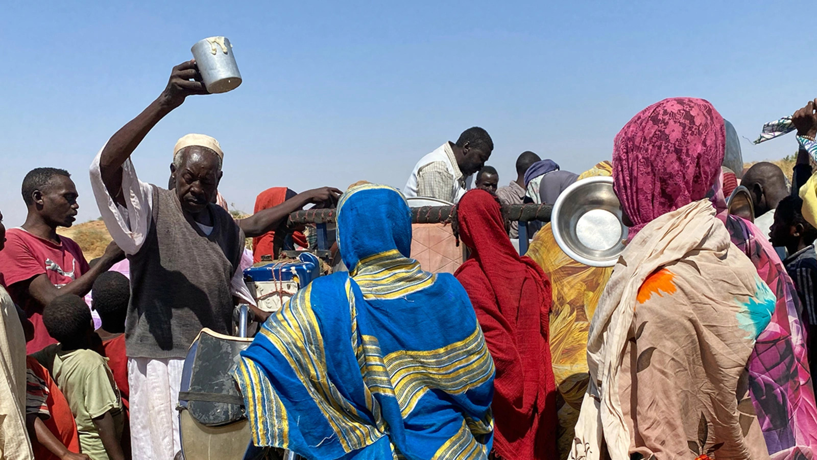 Sudanese receive food at their camp.