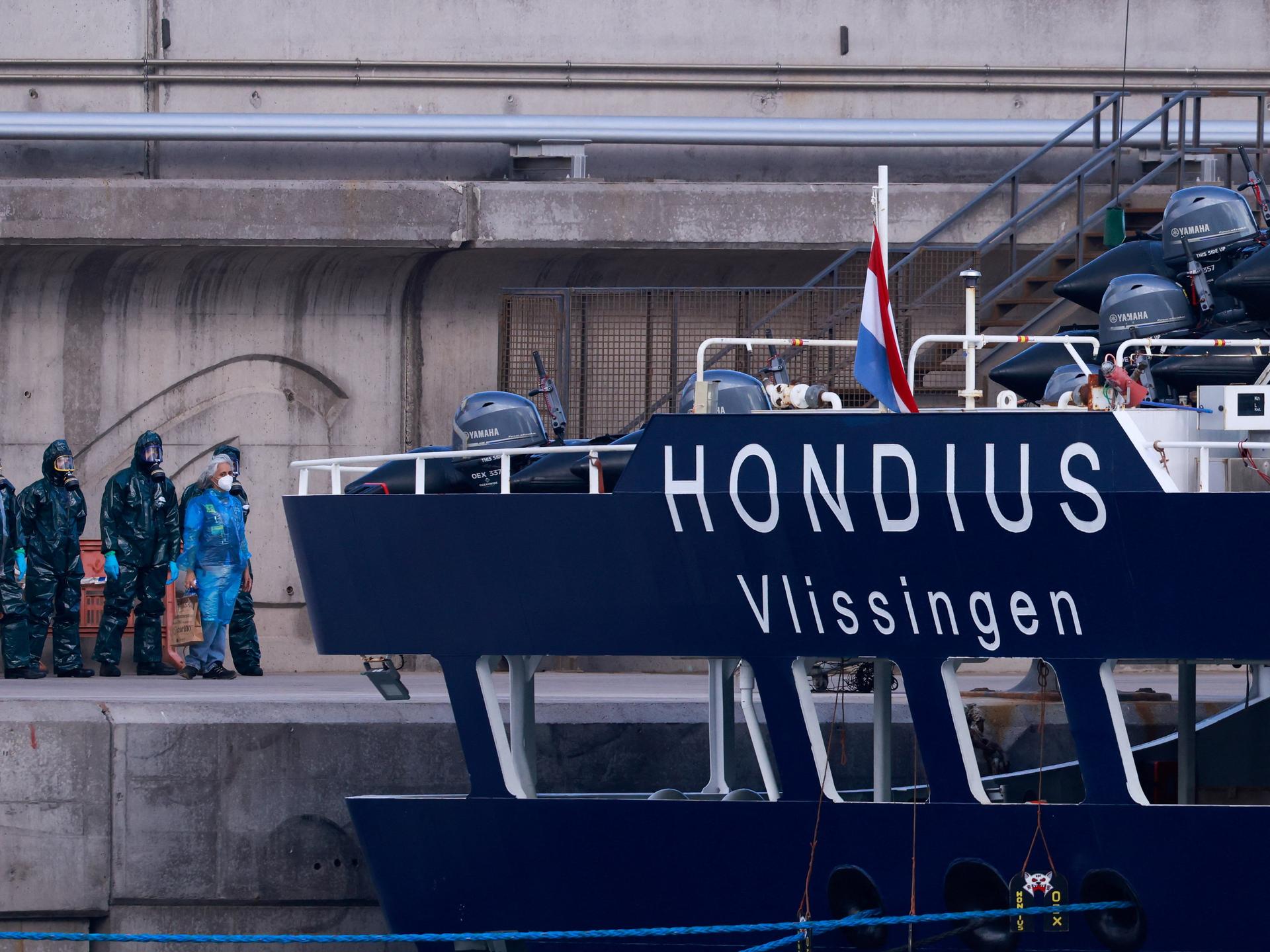 People in hazmat suits and PPE stand near the cruise ship MV Hondius, affected by a hantavirus outbreak, after it docked at the port of Granadilla de Abona, Tenerife, Spain May 11, 2026. REUTERS/Borja Suarez