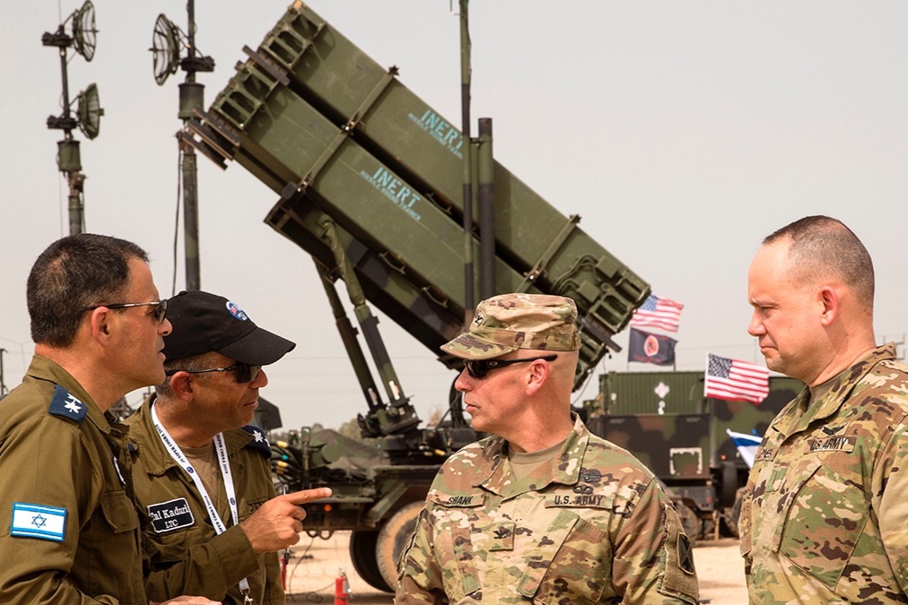 U.S. and Israeli army officers talk in front a US Patriot missile defense system.