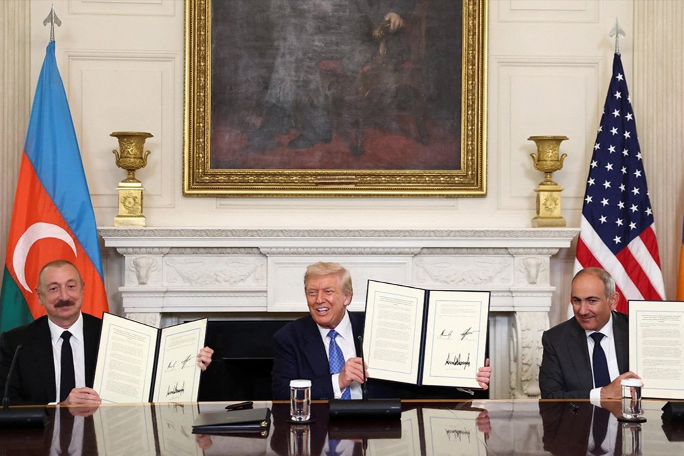 Azerbaijani President Ilham Aliyev, U.S. President Donald Trump, and Armenian Prime Minister Nikol Pashinyan hold up their signed agreements at the White House on August 8.