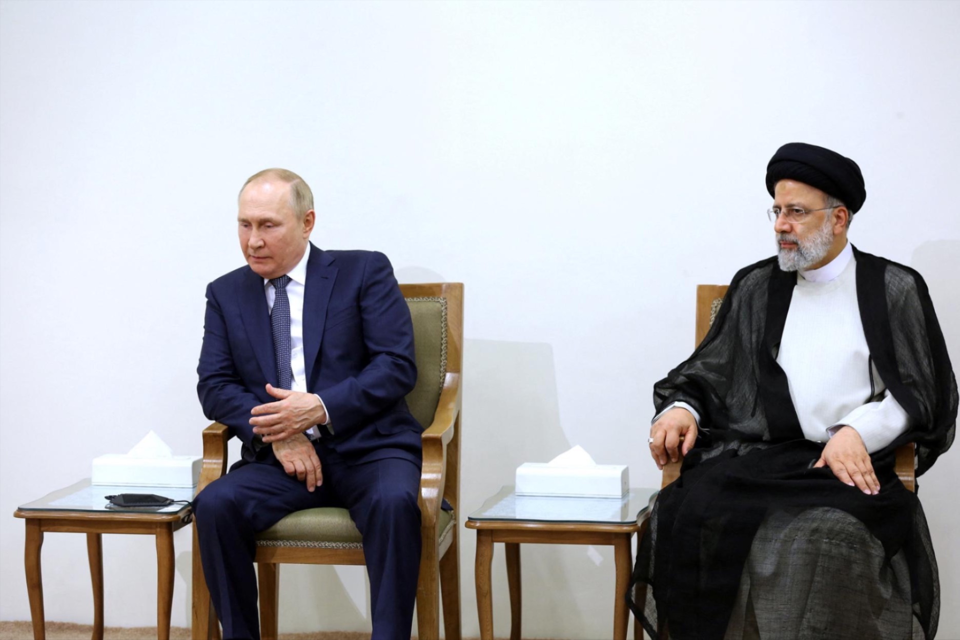 Russian President Vladimir Putin sits next to former Iranian President Ebrahim Raisi during a meeting in Tehran, Iran July 19, 2022. 
