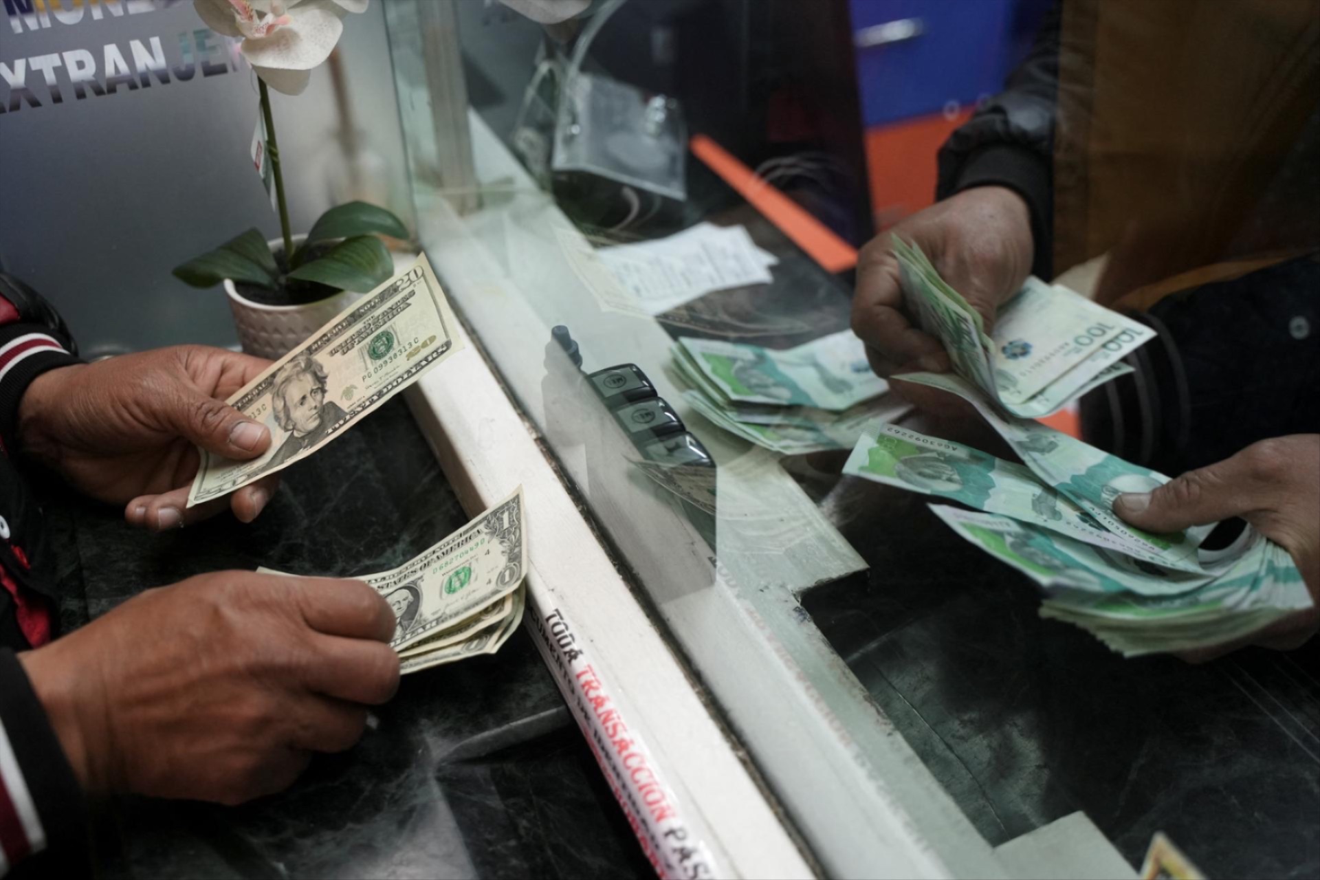 A person exchanges U.S. dollars for Colombian pesos at a currency exchange house in Bogota, Colombia, on June 10.