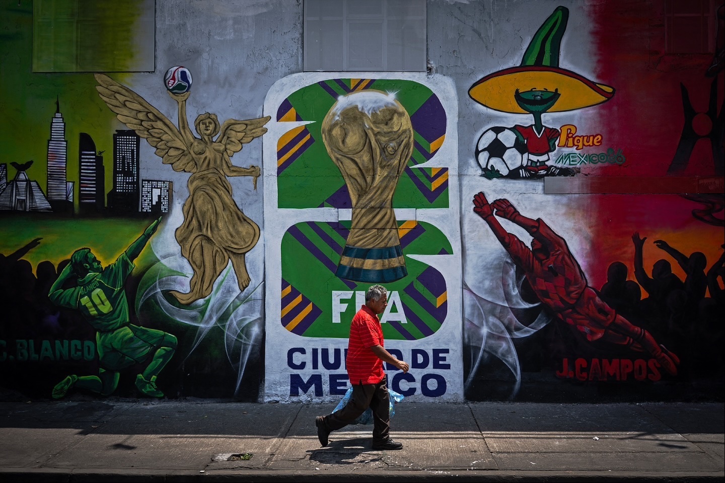 A man walks down a Mexico City sidewalk past a mural celebrating the FIFA World Cup 2026. The competition will kick off with the opening game at Mexico City’s iconic Azteca Stadium, newly renamed the Banorte Stadium, on June 11. 