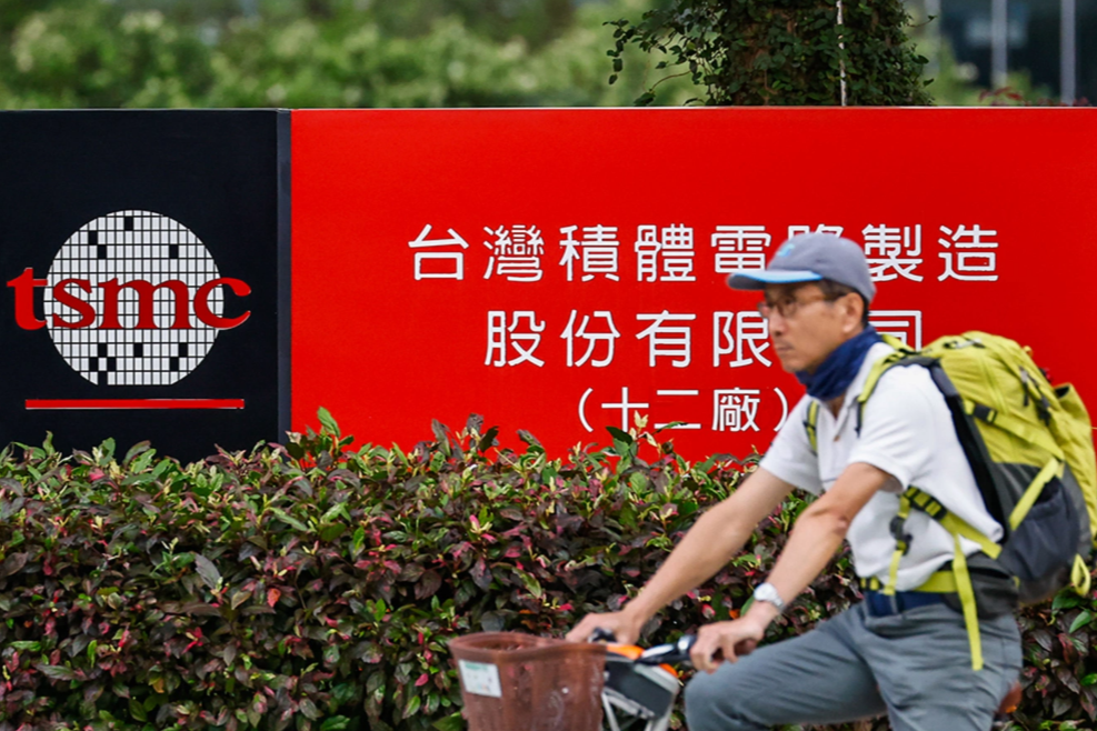 A cyclist waits for traffic lights in front of the logo of the Taiwan Semiconductor Manufacturing Company (TSMC) in Hsinchu, Taiwan, April 16, 2025. Daniel Ceng/Getty Images