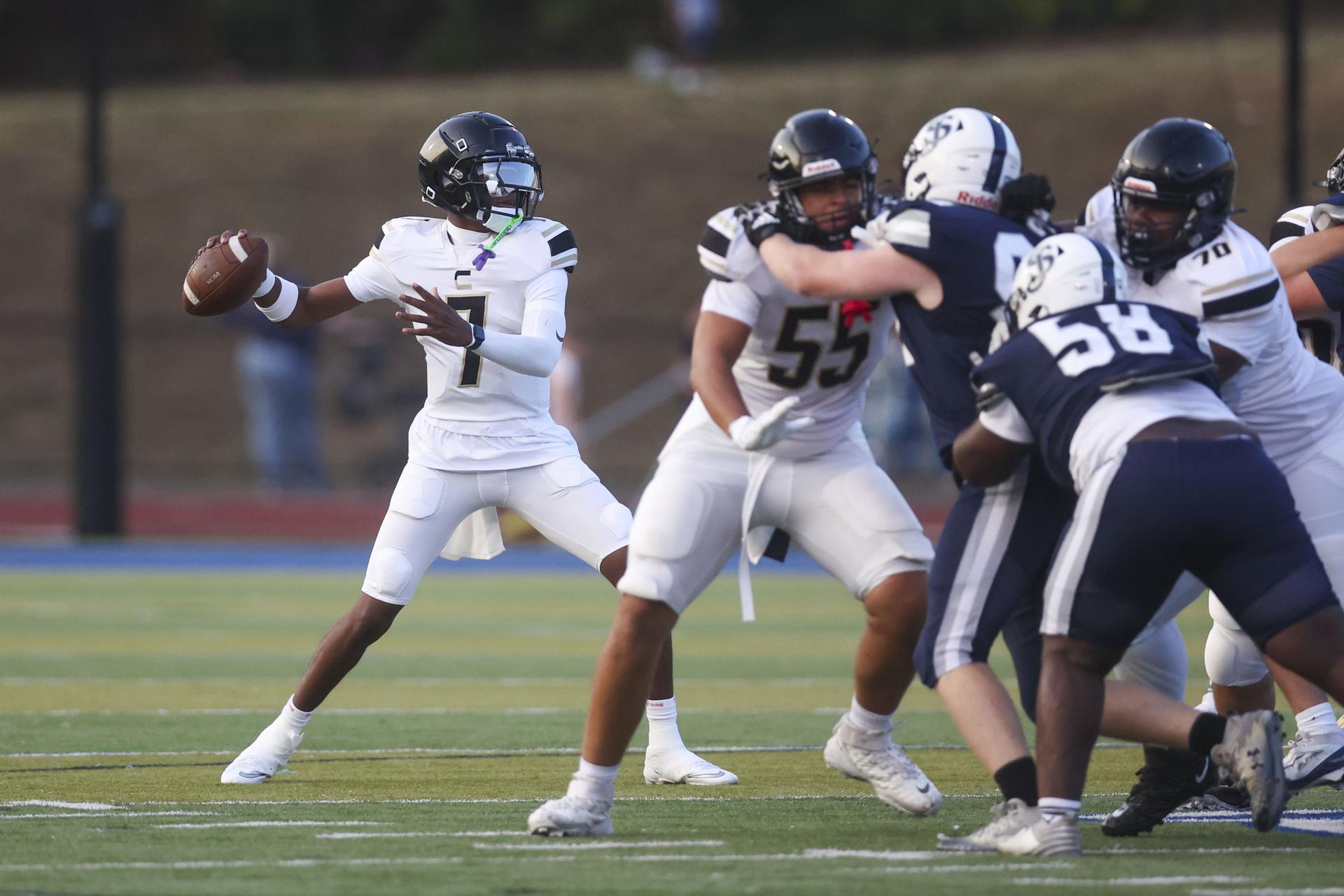Kayakers on the water pass a rock formation