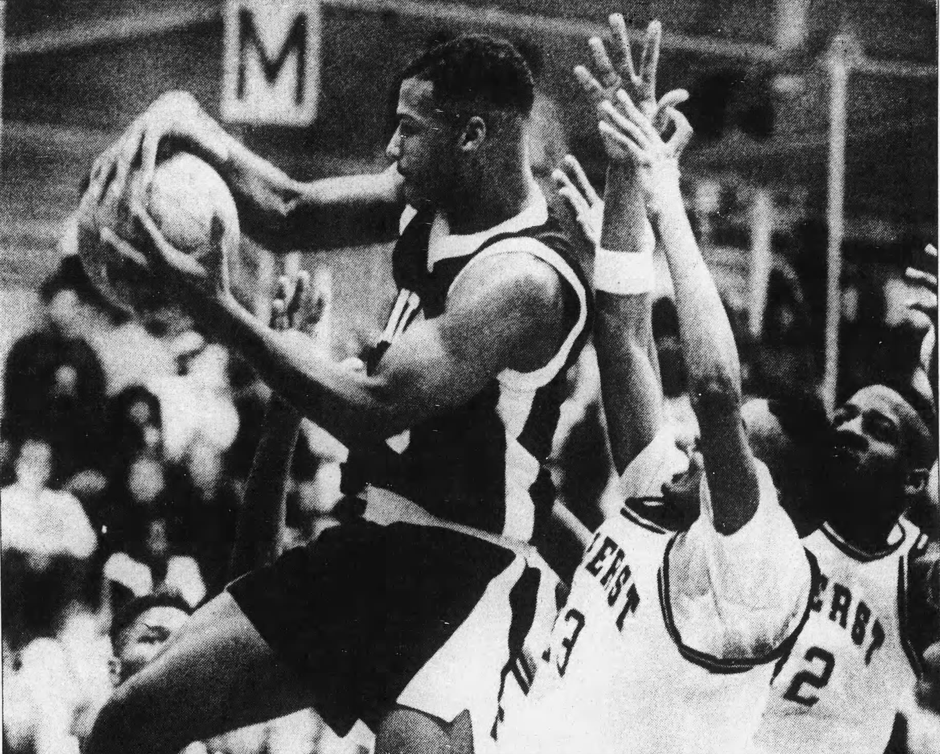 Kayakers on the water pass a rock formation