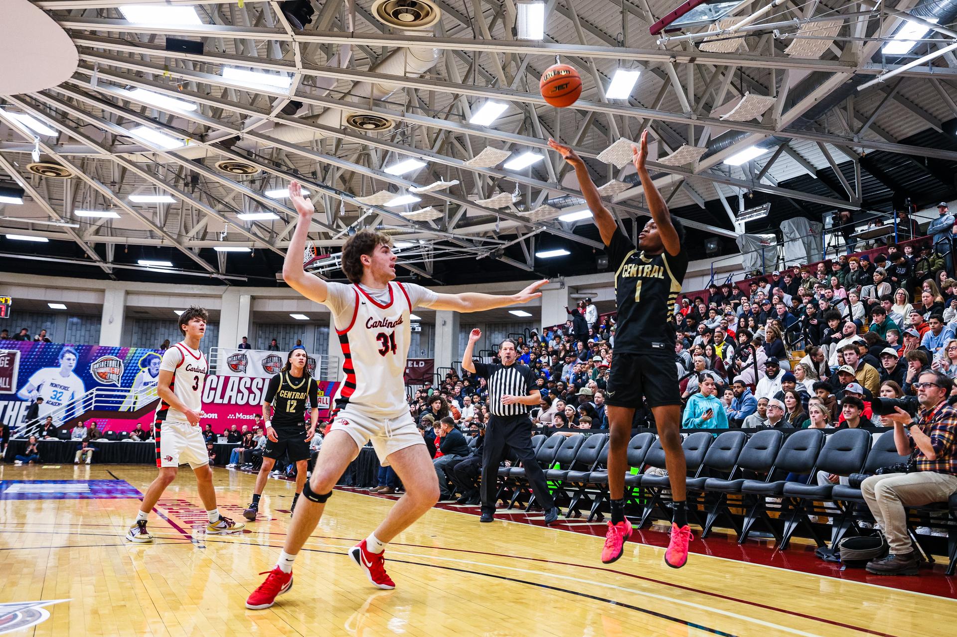 Kayakers on the water pass a rock formation