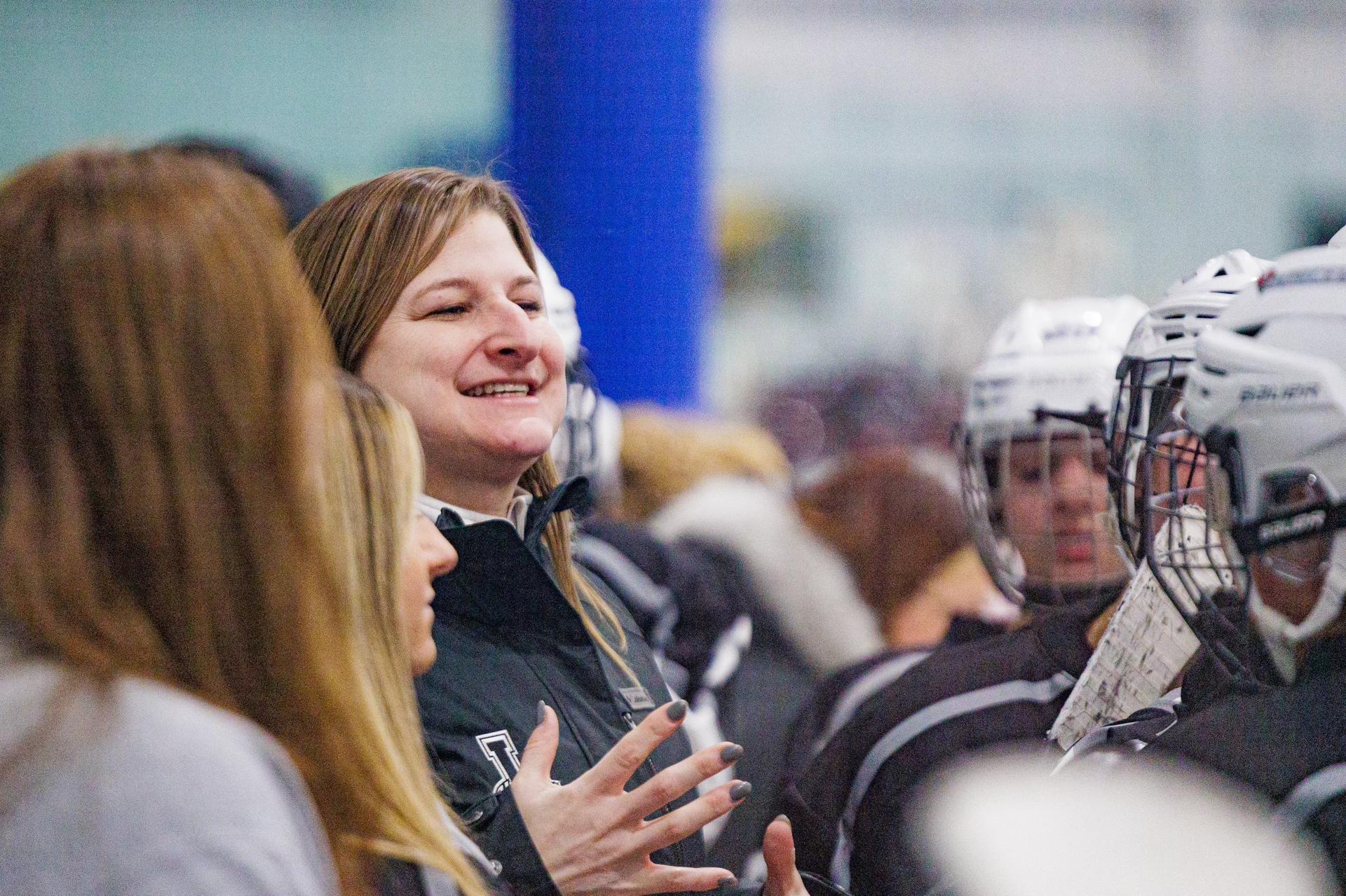 Kayakers on the water pass a rock formation