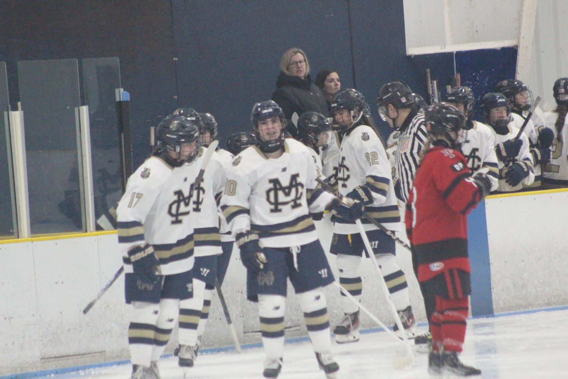 Kayakers on the water pass a rock formation
