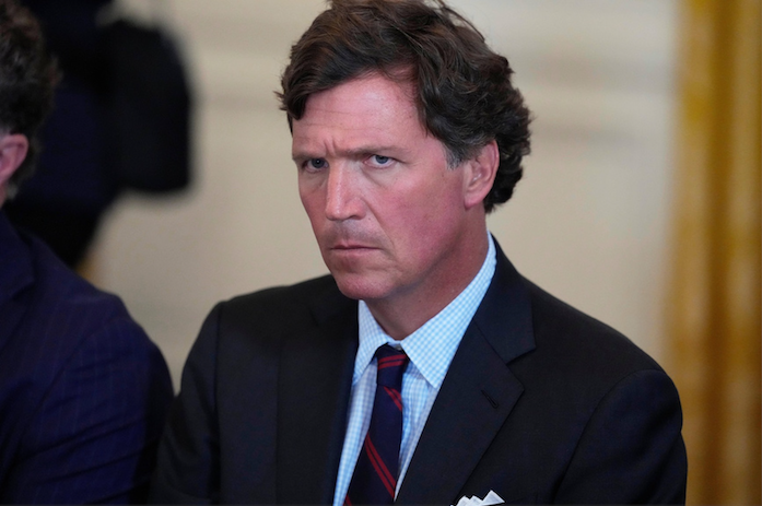 Tucker Carlson, a middle-aged Caucasian man, makes a concerned facial expression.