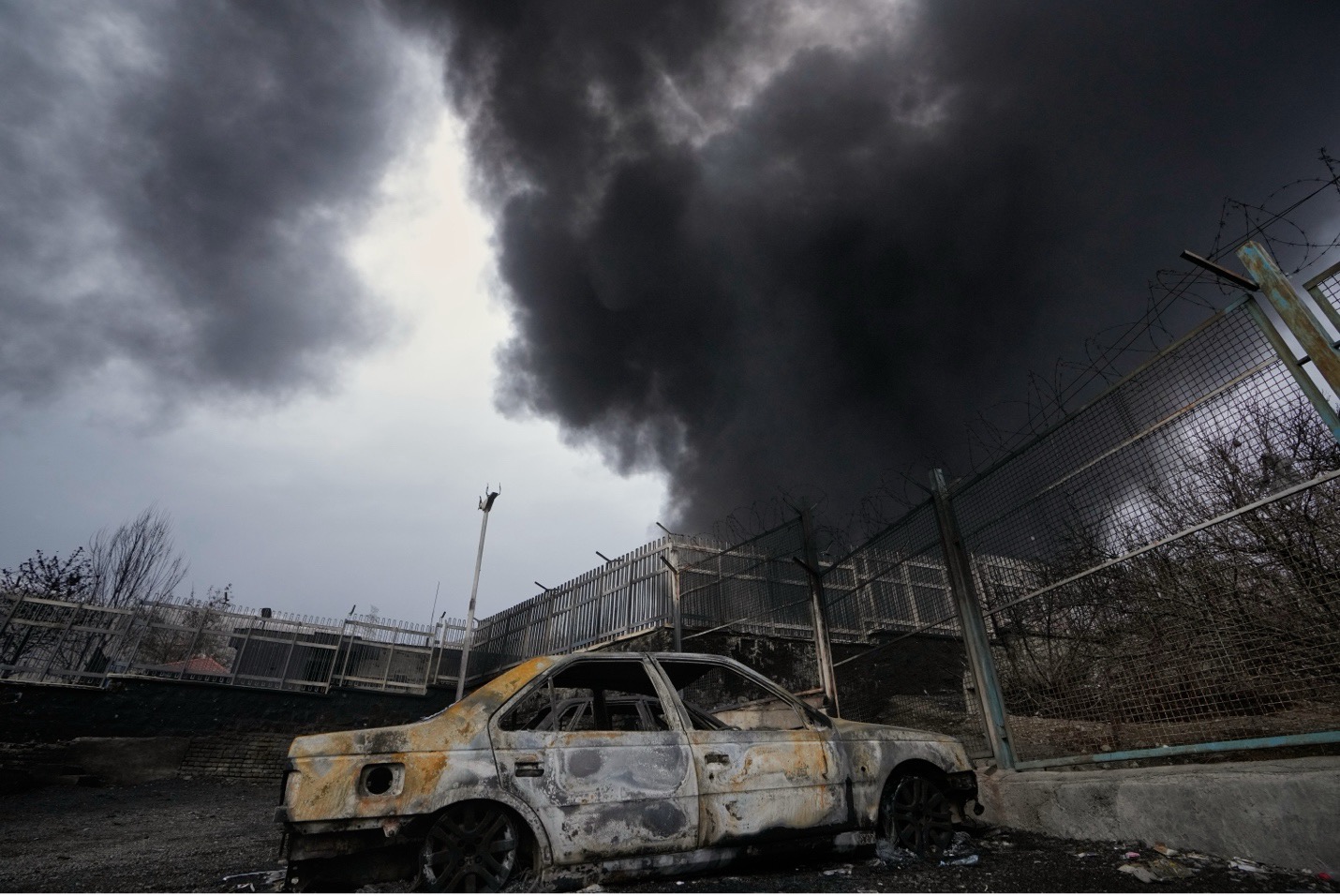 A plume of smoke rises from an oil storage facility hit by a US-Israeli strike on Saturday in Tehran. Vahid Salemi/AP