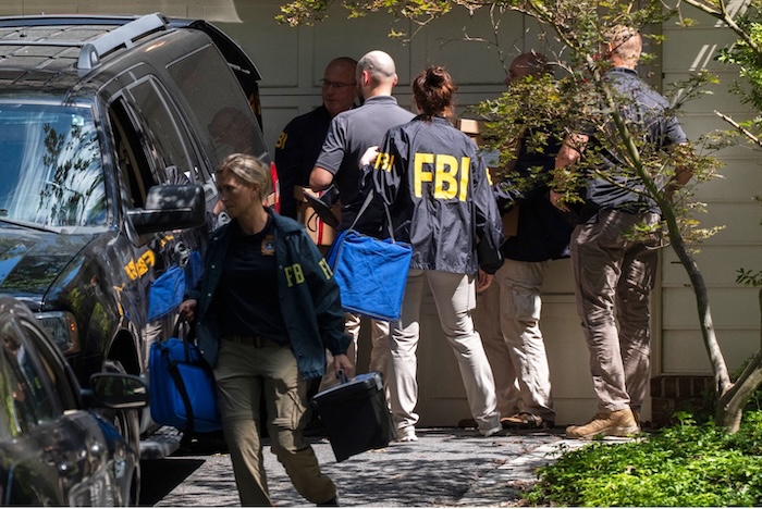 FBI agents carrying out a raid at the home of former National Security Adviser John Bolton on Friday in Bethesda, Maryland. Manuel Balce Ceneta/AP