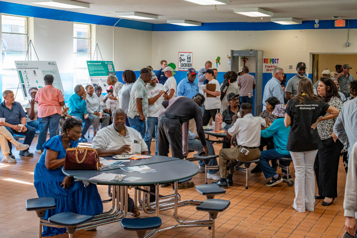 A photo of dozens of people gathered in a middle school for an open house with data center developers.