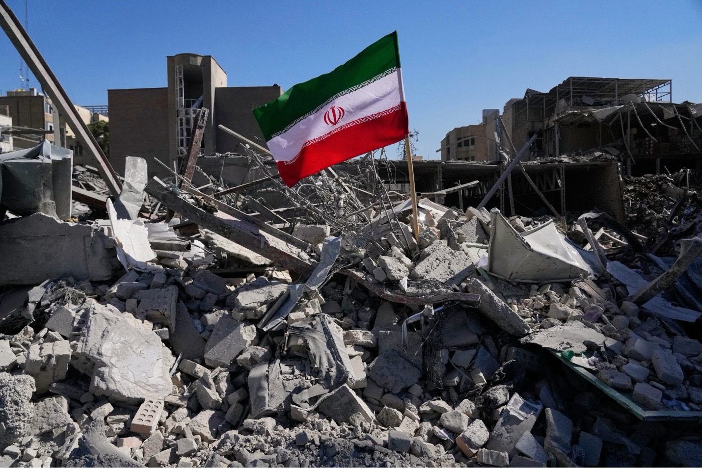 An Iranian flag among the ruins of a police station struck during the US-Israeli military campaign in Tehran on March 3. Vahid Salemi/AP
