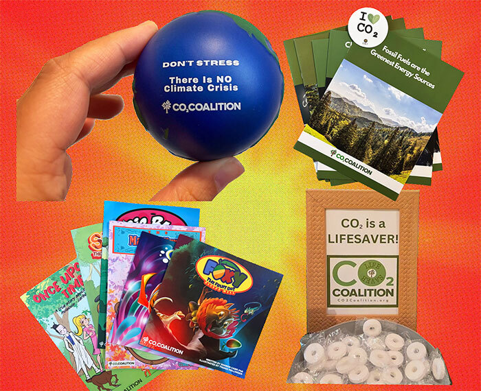 Several pieces of conference swag on an orange background, including mints that say CO2 is a lifesaver, pamphlets calling fossil fuels the greenest energy sources, children's books, and a stress ball that looks like the earth and says Don't stress. There is NO climate crisis.