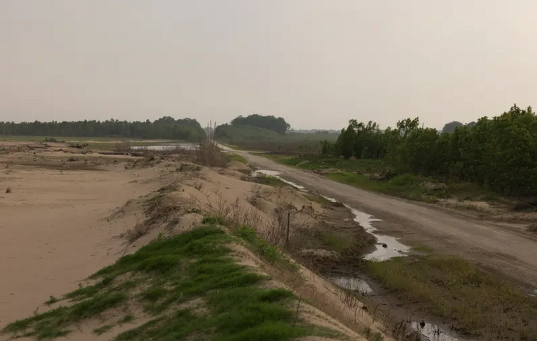 Piles of sand look like dunes on what used to be more productive land for farming.