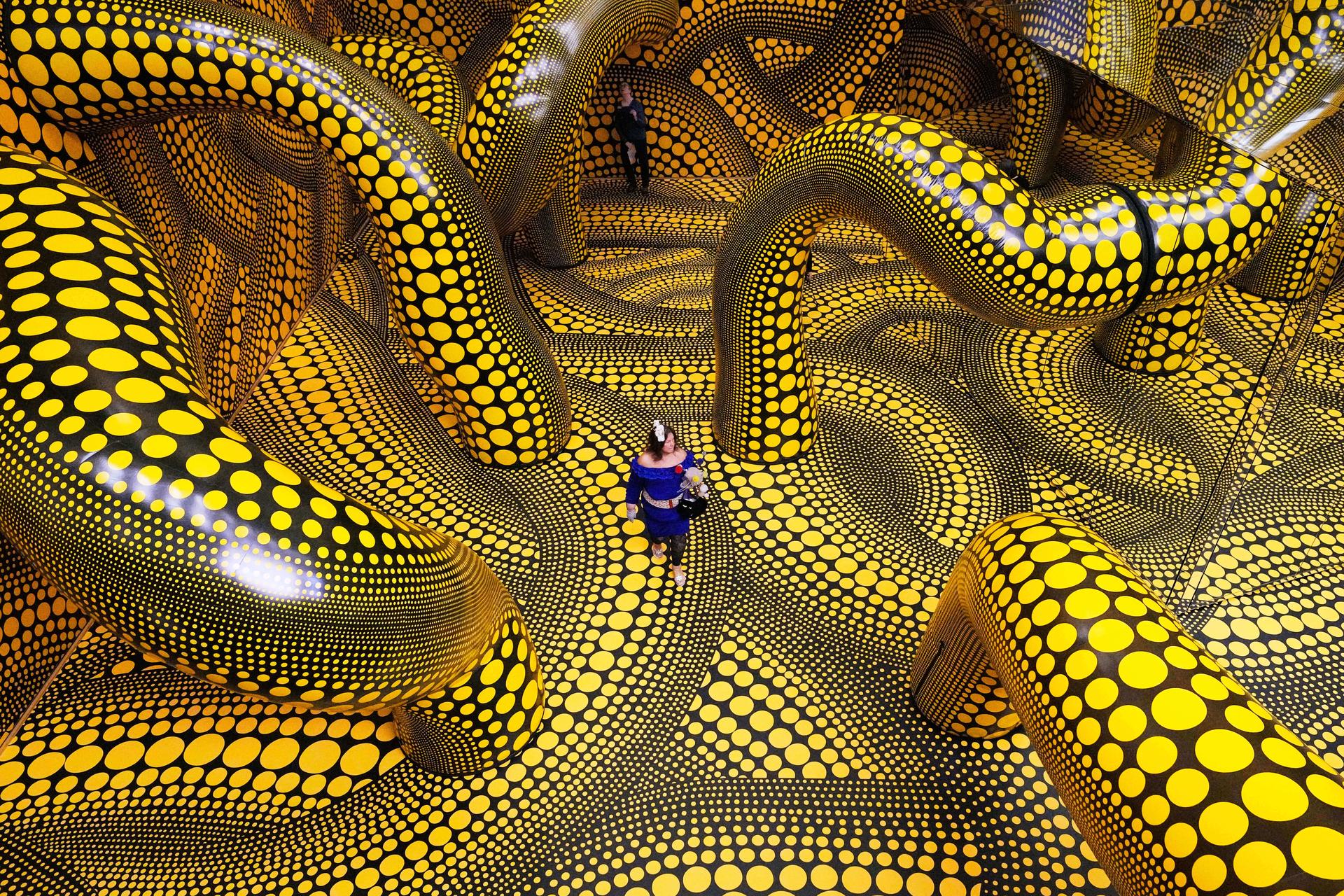 People walk through the artwork 'Infinity Mirrored Room' during a preview of the new major exhibition of legendary Japanese artist Yayoi Kusama at the Museum Ludwig in Cologne, March 12.