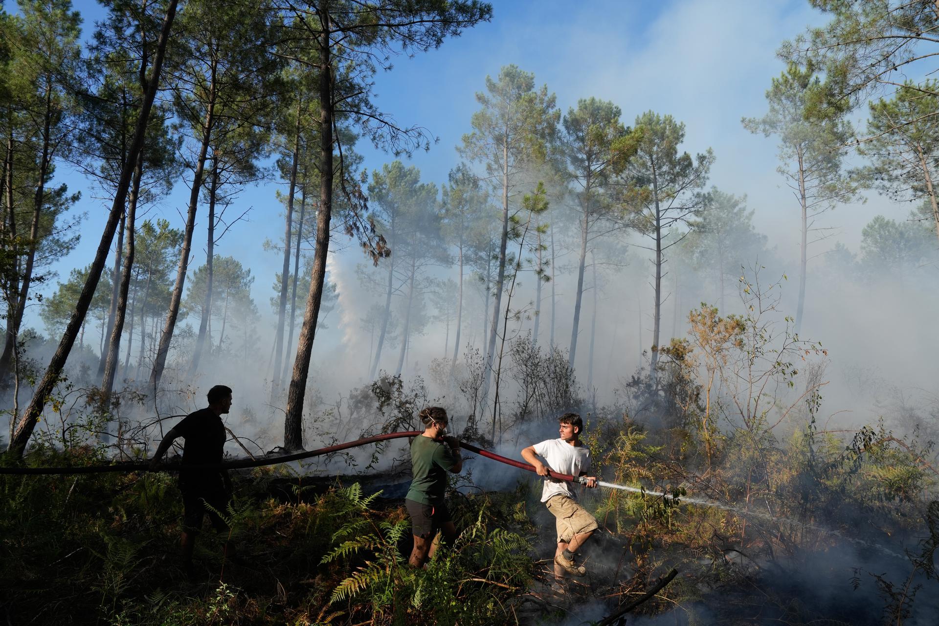 A group tries to suppress a fire as wildfires rage outside Bordeaux, France, Monday.