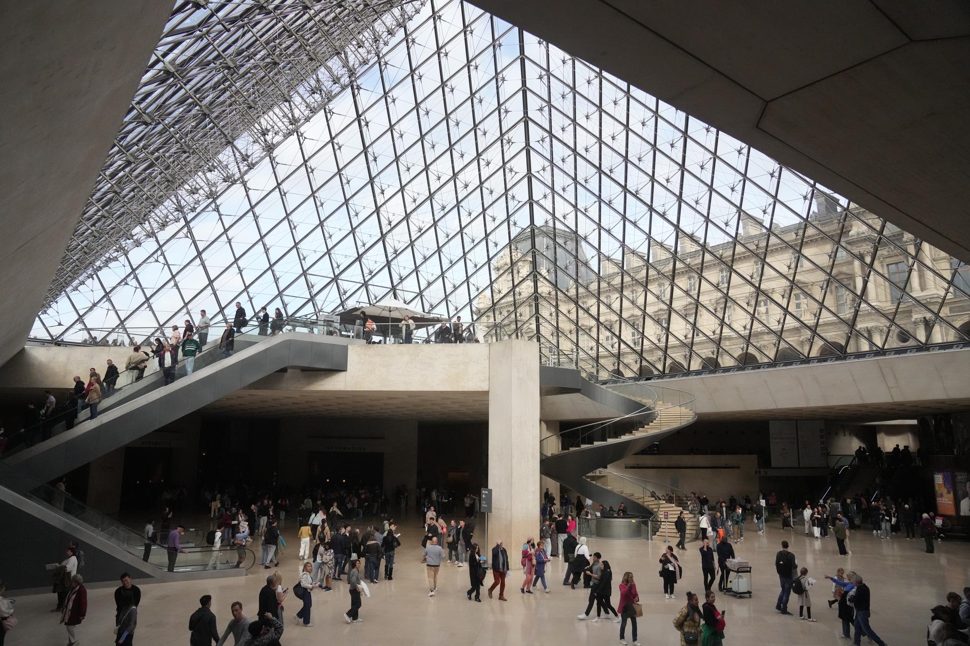 Visitors walk in the lobby of the Louvre museum in Paris on Wednesday. (AP Photo/Thibault Camus)