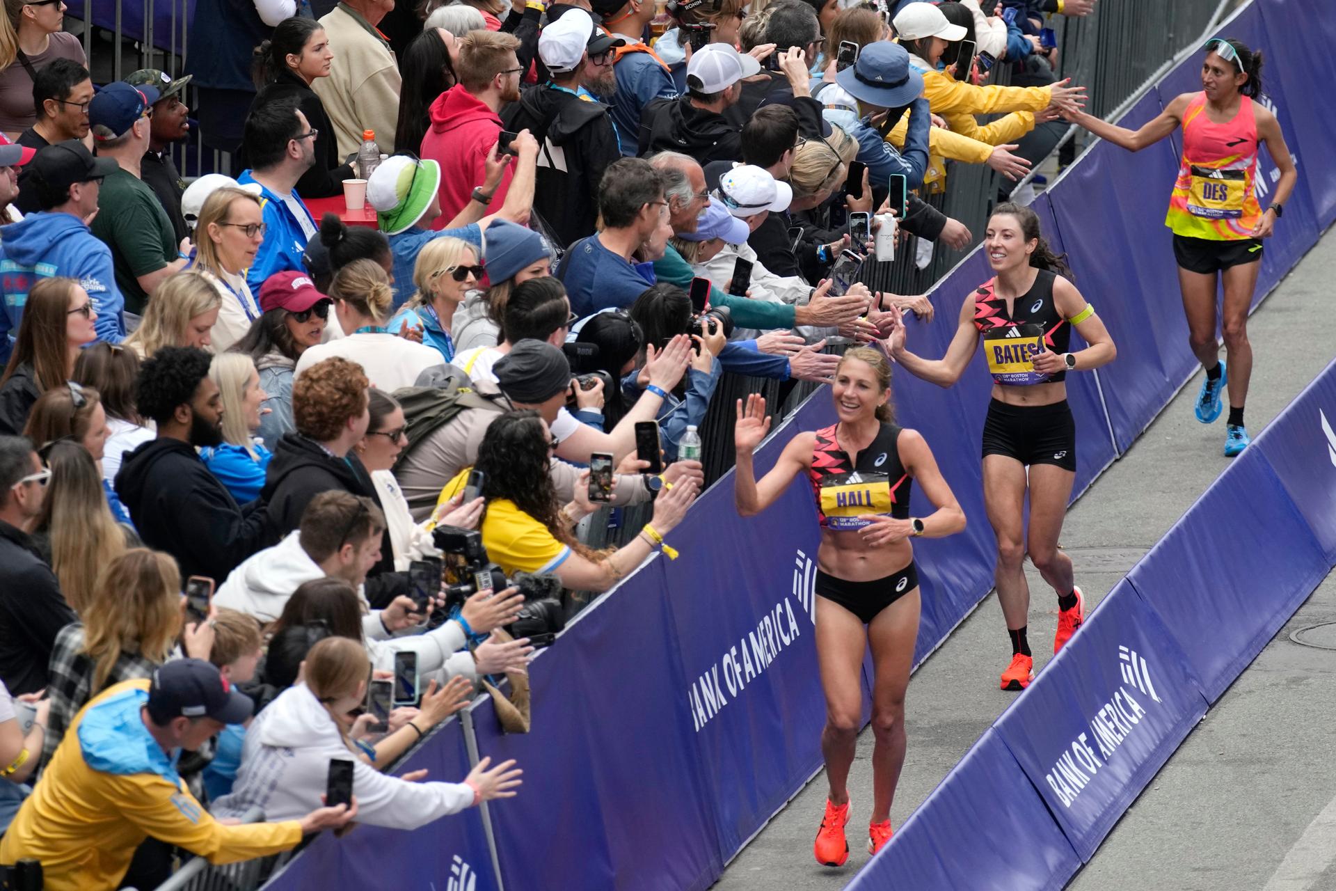American women finishers celebrate with the crowd at the Boston Marathon, 2024, in Boston. 